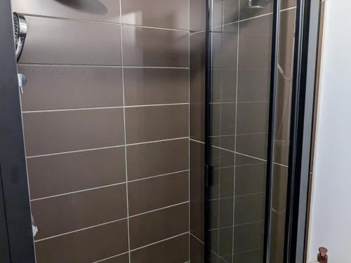 a shower with a glass door in a bathroom at Appartement romantique à Verdun avec parking privé - FR-1-585-168 in Verdun