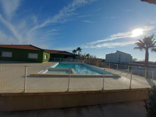 une piscine entourée d'une clôture dans l'établissement Appartement 2 pièces avec terrasse privée et parking - FR-1-326-841, à Marseillan
