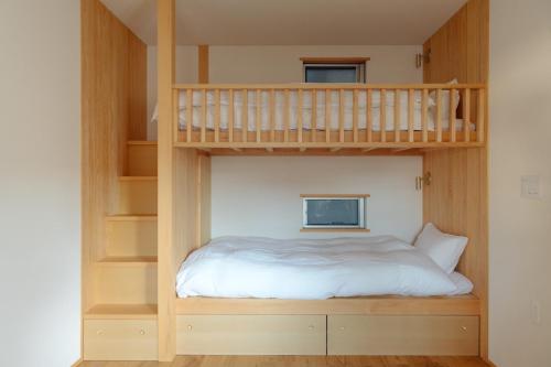 a bedroom with a bunk bed and a staircase at 旅宿ときじくTokijiku in Nachikatsuura
