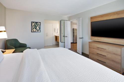 a hotel room with a bed and a flat screen tv at Staybridge Suites Omaha 80th and Dodge by IHG in Omaha