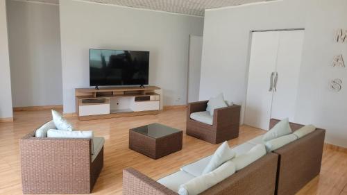 a living room with two couches and a flat screen tv at Villa MAS - Condominio Hacienda II in Pachacamac
