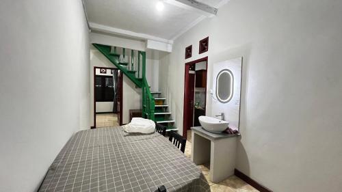 a bedroom with a bed and a sink and a staircase at Diputera home in Sindanglaya
