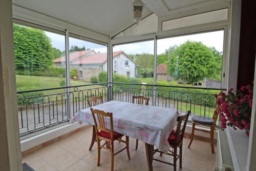 une véranda avec une table et des chaises dans l'établissement Les marronniers, à Sainte-Anne-Saint-Priest