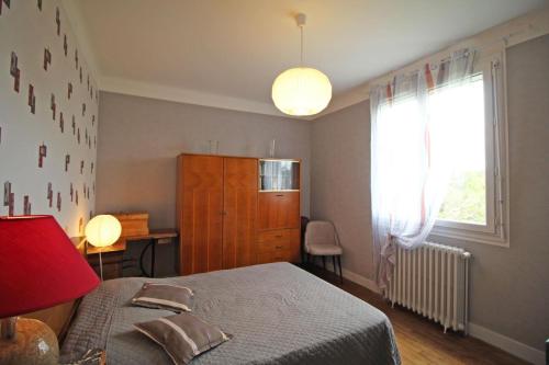 une chambre avec un lit, une commode et une fenêtre dans l'établissement Les marronniers, à Sainte-Anne-Saint-Priest