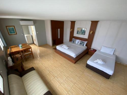 a hotel room with two beds and a couch at Green Beach Pattaya in North Pattaya