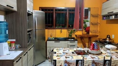 サン・ガブリエウにあるHouse Medeirosのキッチン(ステンレス製の冷蔵庫、テーブル付)