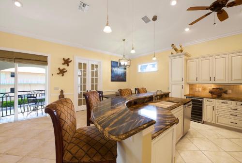 a kitchen with a large island with bar chairs at Casa del Sol Breeze by Sun Palace Vacations in Fort Myers Beach