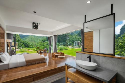 a bedroom with a large bed and a large window at Yangshuo 1Q84 Tree Hotel in Yangshuo