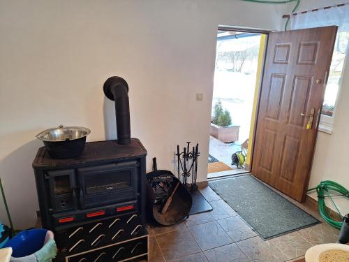 a wood stove in a room with a door at Vila Pohoda Javorníky s rozľahlým pozemkom in Makov