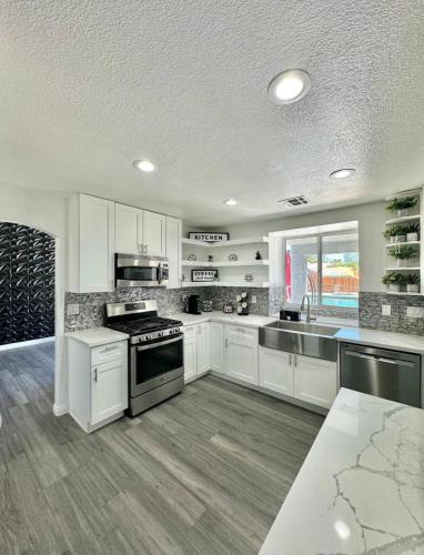 a kitchen with white cabinets and stainless steel appliances at Blue Waterfalls in Las Vegas