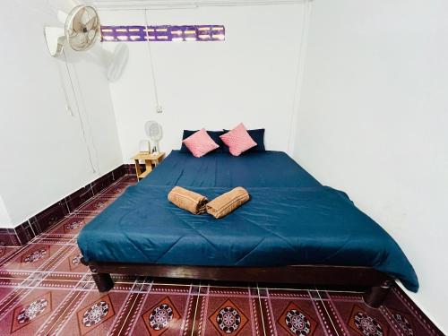 a bedroom with a blue bed with two pillows at Happiness Guesthouse in Koh Rong Sanloem