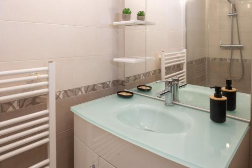 une salle de bain avec un lavabo et un miroir dans l'établissement Cosy entre Paris & Disney, à Bry-sur-Marne