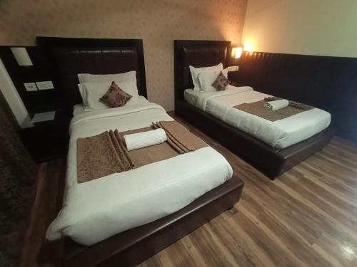 a hotel room with two beds in a room at #The Vaikunth# Mcleodganj# Dhauladhaar View# Big free Parking# Ac rooms Centrally#Elevator#Soundproof rooms# in Dharmsala