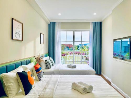 two beds in a room with a window at Novaworld Phan Thiết Bình Thuận view bể bơi, gần biển, 4PN chủ nhà host can speak English in Bình Tú