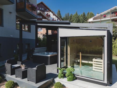 a glass extension of a house with two teddy bears at Hotel Fantelli in Folgarida
