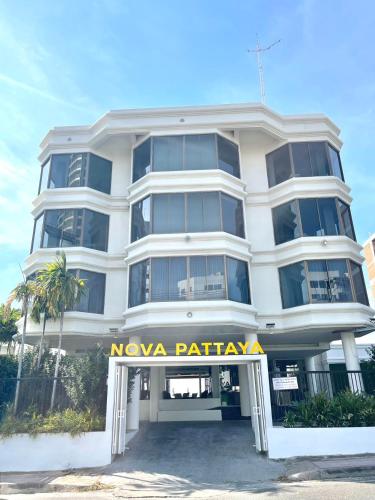 a white building with a nova party sign in front of it at 秘狗Nova Hotel in Pattaya South