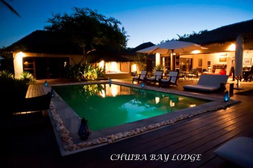 a swimming pool in a backyard at night at Chuiba Bay lodge in Pemba
