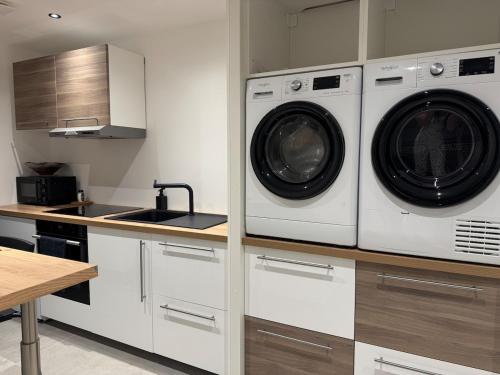 une cuisine avec un lave-linge et un sèche-linge sur un comptoir dans l'établissement Appartement vue mer, à Plougastel-Daoulas
