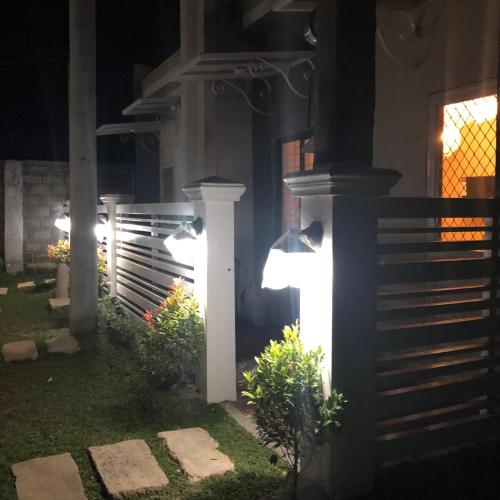 a backyard at night with lights on a fence at Scandinavian Studio with Highspeed internet in Bantug