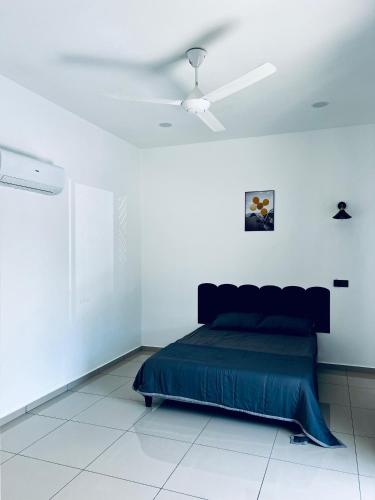 a bedroom with a bed and a ceiling fan at The Rina Homestay-Whole Villa with Private Pool,BBQ & Karaoke-Near Beach- in Port Dickson