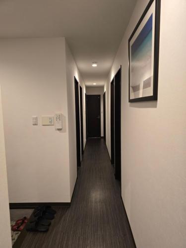 a hallway of a hotel with a painting on the wall at NINN102 - Osaka Itami Airport Guest House 大阪国際空港 伊丹空港 ITM ゲストハウス ニン in Ikeda
