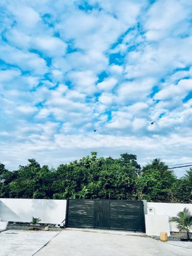 a black gate with a sky with clouds at The Rina Homestay-Whole Villa with Private Pool,BBQ & Karaoke-Near Beach- in Port Dickson