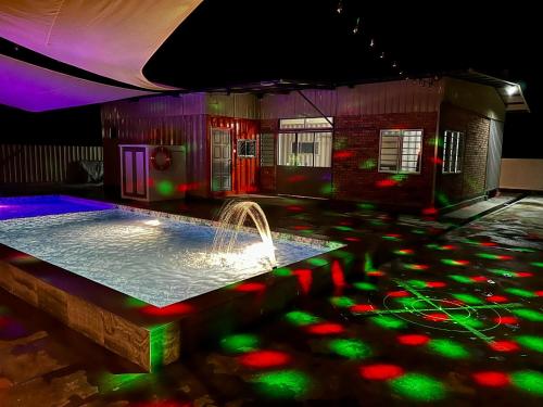 a pool with a fountain in a room with lights at The Rina Homestay-Whole Villa with Private Pool,BBQ & Karaoke-Near Beach- in Port Dickson