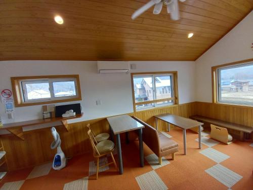 a waiting room with a table and chairs and windows at Orange Cabin Inn far from station in Fujikawaguchiko