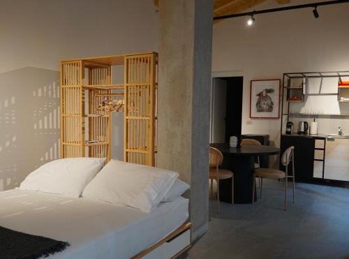 a bedroom with a bed with a wooden headboard and a table at SANBE 17 Loft House in Bergamo