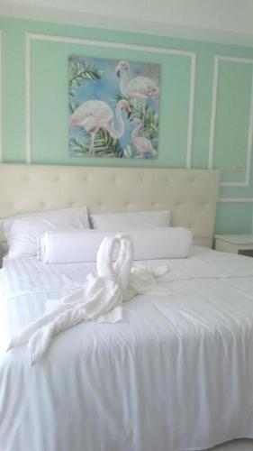 a white bed with two white swans sitting on it at Mestyle Resort in Chumphon