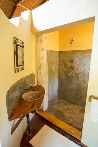 a bathroom with a sink and a shower at Tree House Cottage, Garden Views, Hot Water in Praia do Tofo