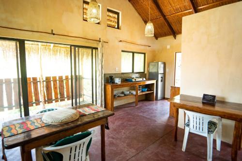 a kitchen with a table and chairs in a room at Tree House Cottage, Garden Views, Hot Water in Praia do Tofo