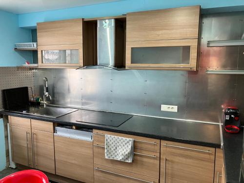 une cuisine avec un comptoir en acier inoxydable dans l'établissement 3 chambres cozy proche de Paris, à Argenteuil