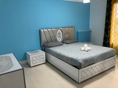 une chambre avec un lit et un mur bleu dans l'établissement 3 chambres cozy proche de Paris, à Argenteuil