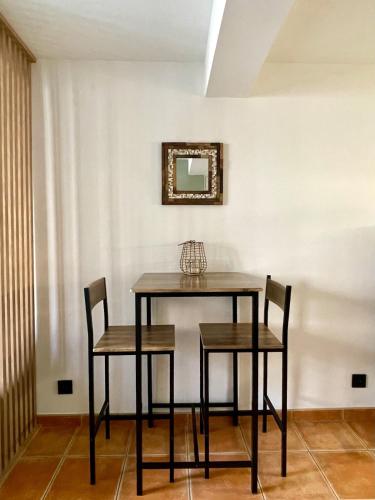 une table de salle à manger avec deux chaises et un miroir dans l'établissement Charmant studio Vieux-Toulon, à Toulon