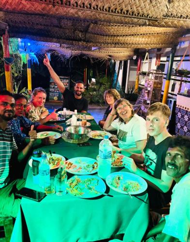 a group of people sitting around a table eating food at Viraj's Garden in Tangalle