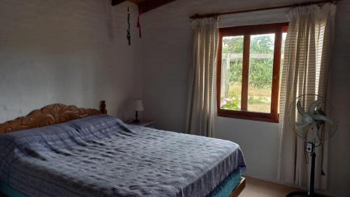 a bedroom with a bed and a window at Mar de fondo in La Paloma