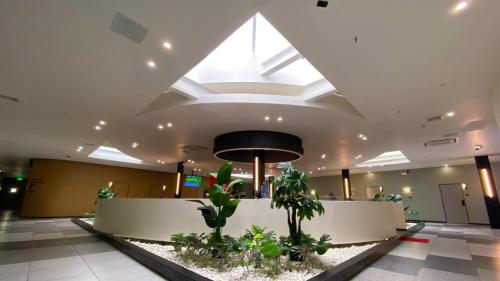 a lobby with a large skylight and plants at Fan's Hotel Baybay in Baybay