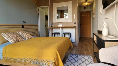 a bedroom with a large bed and a kitchen at Studio avec terrasse privative in Albi