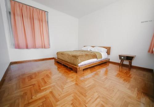 une chambre avec un lit et un parquet dans l'établissement Villa Istana Bunga - The Green Villa 4 Bedroom, à Bandung