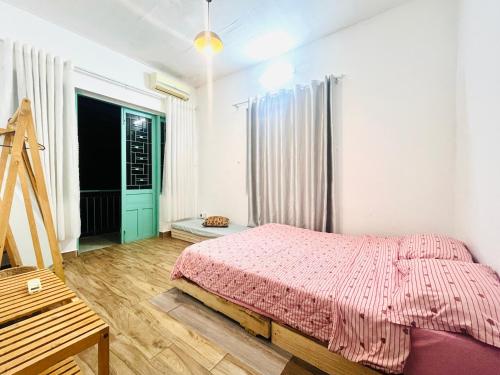 a bedroom with a bed with a pink blanket at SIII Vũng Tàu Garden coffee & homestay in Vung Tau