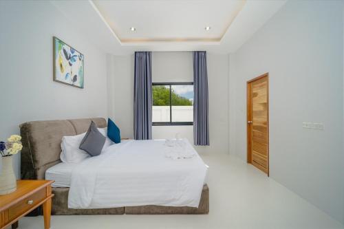 a bedroom with a bed and a couch and a window at Stay Pool Villa in Ao Nang Beach