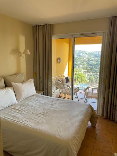 une chambre d'hôtel avec un lit et un balcon dans l'établissement Blue Bay Issambres, aux Issambres