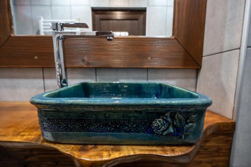 ein blaues Waschbecken im Bad mit Spiegel in der Unterkunft Къща за гости Приказка in Klisura