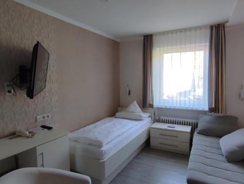 a small room with a bed and a couch at Hotel Stockhausen GbR in Schmallenberg