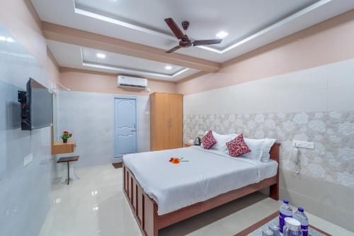 a bedroom with a bed and a ceiling fan at Sam Residency in Puducherry
