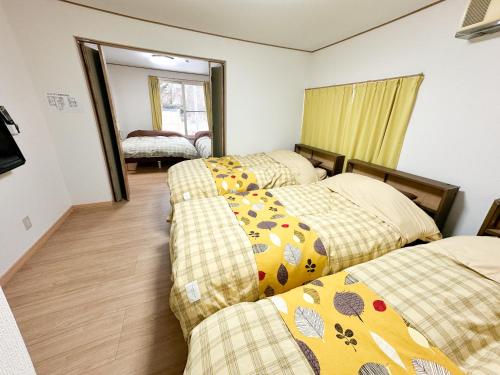 a room with three beds and a mirror at M&TTT in the nature in Shiraoi