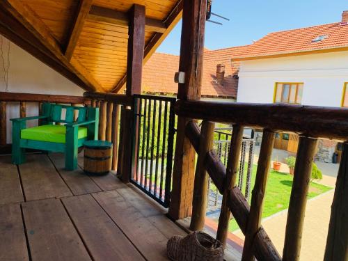 a wooden porch with a bench and a chair at Casa "La Moara din Grădină" in Eftimie Murgu