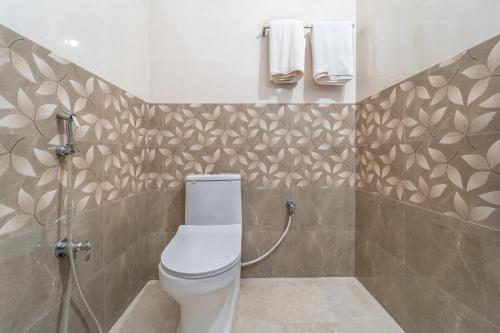 a bathroom with a toilet and a shower at Sam Residency in Puducherry