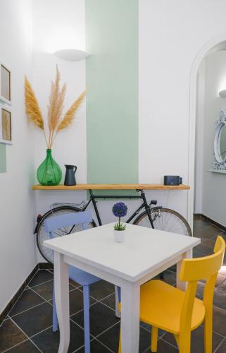 a dining room table with yellow and blue chairs at Maison Patricia in Lecce